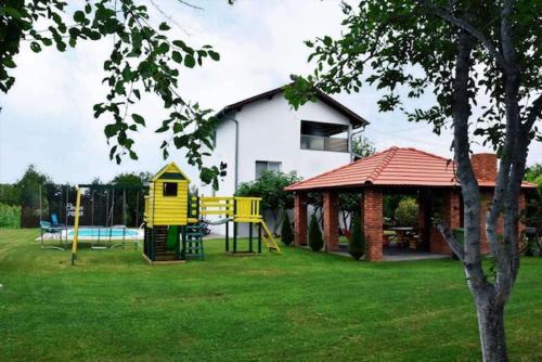 a yard with a playground and a house at Vila Oaza mira in Vražići