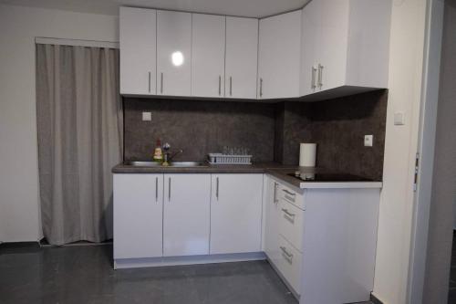 a kitchen with white cabinets and a sink at Vila Oaza mira in Vražići