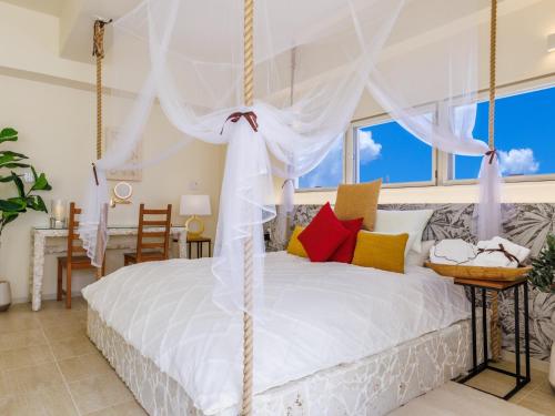 a bedroom with a white bed with a swing at ResortVilla-KAPUKA in Kouri