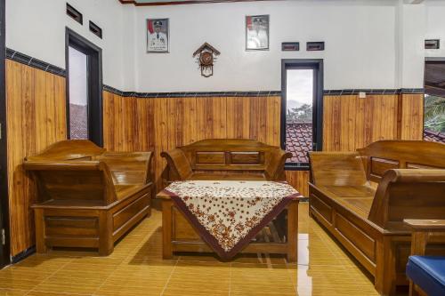 a dining room with wooden chairs and a table at Hotel O Desa Wisata Kawasen in Padaherang