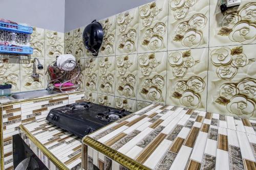 a room with a table and a wall covered in gold at Hotel O Desa Wisata Kawasen in Padaherang