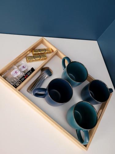 - un plateau en bois avec des tasses à thé et d'autres articles dans l'établissement Studio indépendant à 5 minutes du Puy DuFou, à Chambretaud