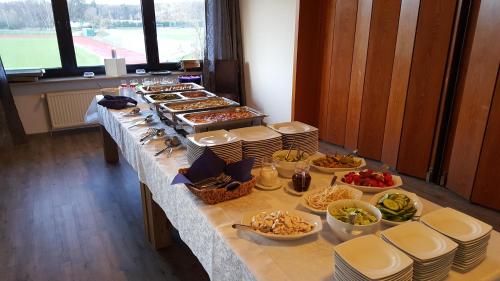 a buffet line with plates and bowls of food at Hotel Restaurant Teichaue in Adendorf