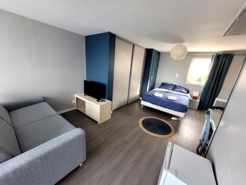 - un petit salon avec un canapé et un lit dans l'établissement Studio indépendant à 5 minutes du Puy DuFou, à Chambretaud