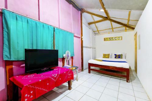 a room with a bed and a tv in a room at OYO Homes 91154 Desa Wisata Wayang Manyaran Wonogiri in Wonogiri