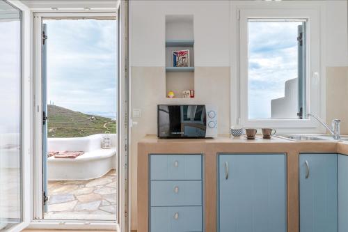 a bathroom with a sink and a tub and a window at Vassilis Family Villa Tinos in Triandáros