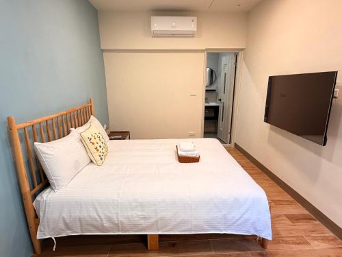 a bedroom with a bed with a television on the wall at Lin's House in Ch'ih-k'an-lou