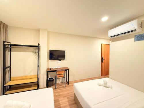 a hotel room with two beds and a desk at TwinTree Kelawai in George Town