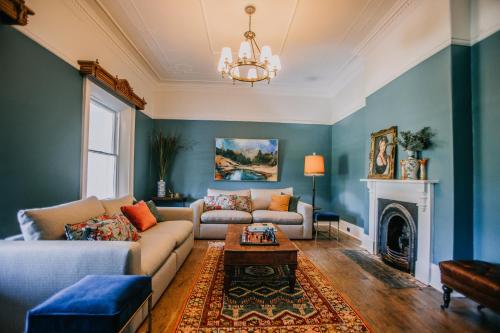 a living room with a couch and a fireplace at Littlebourne Guest House in Bathurst