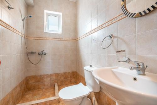 a bathroom with a toilet and a sink and a shower at Villa May Rose in Kalathos