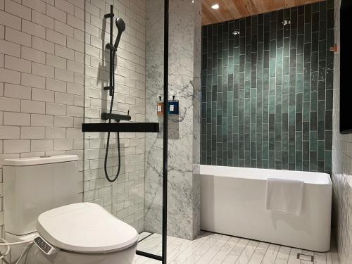a bathroom with a shower and a toilet and a tub at Spring12 House in Chiayi City