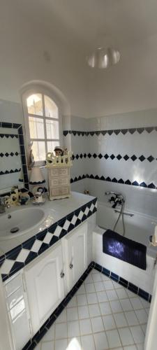 une salle de bain avec un mur à carreaux noir et blanc dans l'établissement Villa Bastide provençale Saint Raphaël Valescure, à Saint-Raphaël