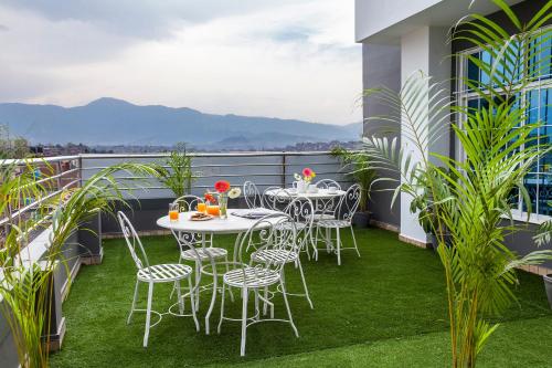 a patio with a table and chairs on a balcony at OYO 123 Hotel Prince Plaza in Kathmandu