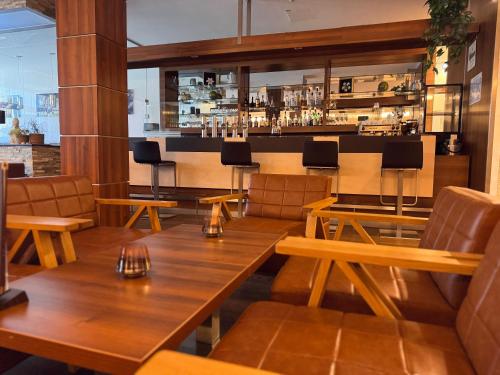a restaurant with wooden tables and chairs and a bar at Hotel Spirodom in Admont
