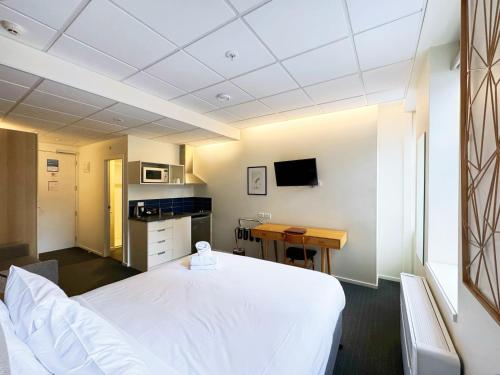 a hospital room with a white bed and a desk at Park Hotel, Lambton Quay in Wellington