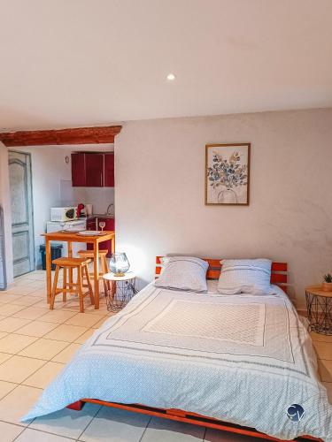une chambre avec un grand lit et une cuisine dans l'établissement Studio en Ardèche, calme et nature au rendez-vous, à Saint-Montan