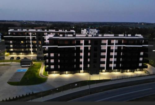 a large building with a parking lot in front of it at Apartament dla dwojga z jacuzzi na wyłączność in Świecie