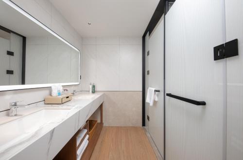 a bathroom with two sinks and a mirror at Hilton Garden Inn Zhangjiajie Wulingyuan in Zhangjiajie