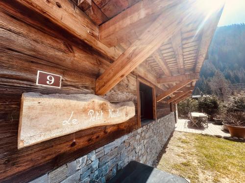 a wooden building with a sign on the side of it at Chalet le petit Nicolas, jacuzzi, vue Mont Blanc in Chamonix-Mont-Blanc