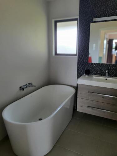 a bathroom with a large white tub and a sink at Secluded Sanctuary in Taupo