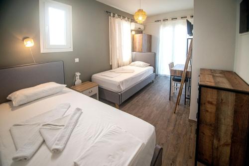 a hotel room with two beds and a table at Ikaria Studios in Agios Kirykos