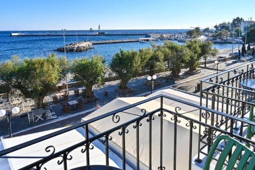 a balcony with a view of the water and a harbor at Ikaria Studios in Agios Kirykos