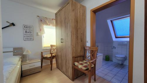 a bedroom with a bed and a bathroom with a toilet at Ferienwohnung Ankerplatz Thiessow in Thiessow