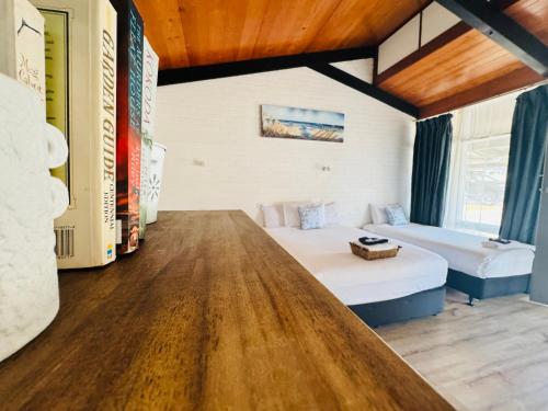 a room with two beds and a wooden floor at Jetty Motel The Entrance in The Entrance