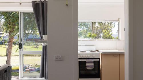 a kitchen with a stove top oven next to a window at Waterfront Cottage in New South Wales 