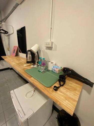 a wooden table with a sewing machine on it at XX GO INN BTS Ari - BTS Ari Station in Sathani Sam Sen
