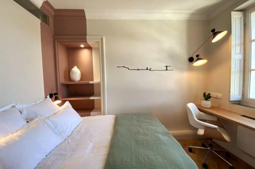 une chambre avec un lit, un bureau et une chaise dans l'établissement Studio with rooftop view of the Graslin Theater, à Nantes