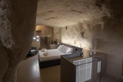 a bedroom in a cave with a bed and a desk at Al Vico Affittacamere in Matera