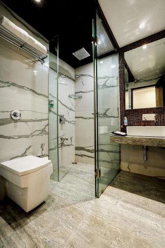 a bathroom with a toilet and a shower and a sink at Kumar Resort By Turtle, Lonavala in Lonavala