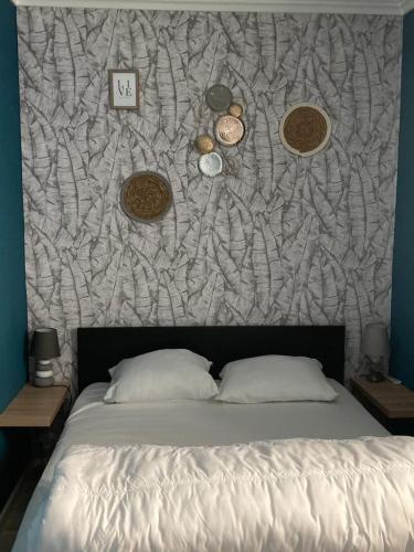 - un lit dans une chambre avec un mur dans l'établissement Les volets verts, au Crotoy