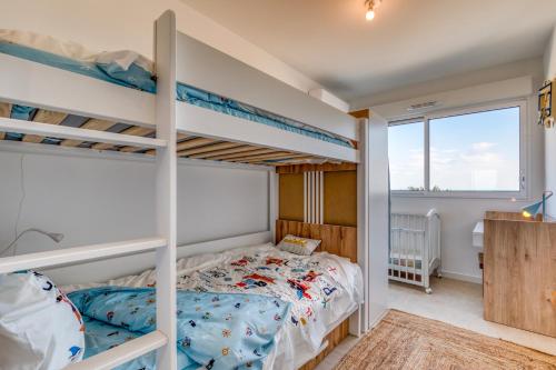 une chambre avec deux lits superposés et un bureau dans l'établissement Appartement Grains de Sable, à Le Castellas