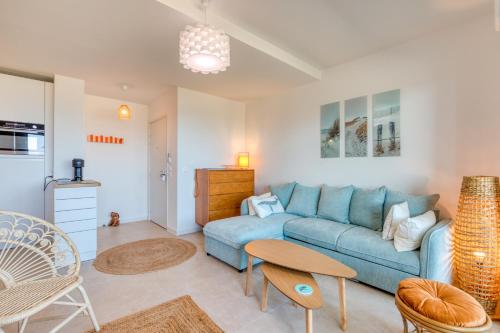 un salon avec un canapé bleu et une table dans l'établissement Appartement Grains de Sable, à Le Castellas