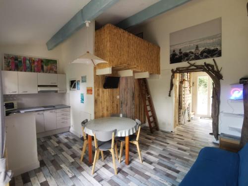une cuisine et une salle à manger avec une table et des chaises dans l'établissement Cabane de la Glisse, à Lacanau