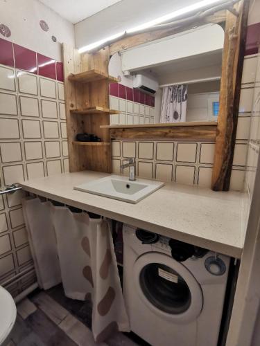 une salle de bain avec un lavabo et une machine à laver dans l'établissement Cabane de la Glisse, à Lacanau