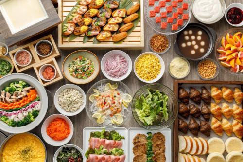 a table topped with lots of different dishes of food at Via Inn Shinsaibashi in Osaka