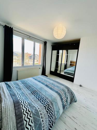 une chambre avec un lit et un grand miroir dans l'établissement Appartement spacieux à Caen, à Caen