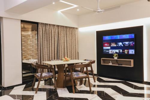 a dining room with a table and chairs and a tv at Kumar Resort By Turtle, Lonavala in Lonavala