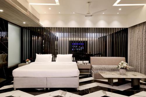 a bedroom with a large bed and a table at Kumar Resort By Turtle, Lonavala in Lonavala