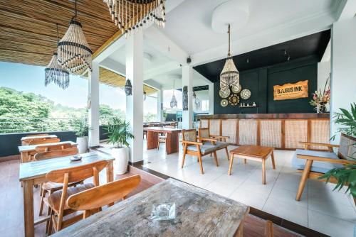 un restaurante con mesas y sillas de madera y una barra en Bagus Ink Surf Camp, en Uluwatu
