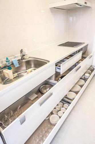 a kitchen with white cabinets and a sink at Shallows in Onna