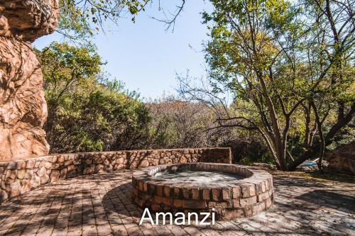 a stone fire pit in a yard with trees at Thabela Thabeng in Parys