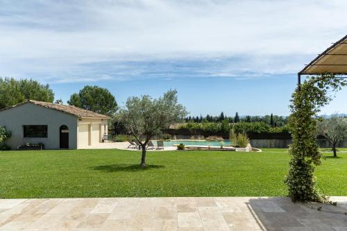 une maison dotée d'une cour verdoyante avec un arbre dans l'établissement Maison style mas « le rougadou », à Noves