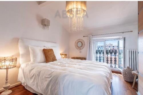 une chambre avec un grand lit blanc et une fenêtre dans l'établissement Antibes centre dernier étage, à Antibes