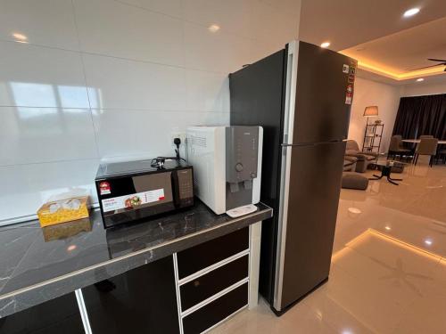 a kitchen with a microwave and a refrigerator on a counter at Cozy Condo in Sandakan, Sri Utama Condominium IJM in Sandakan