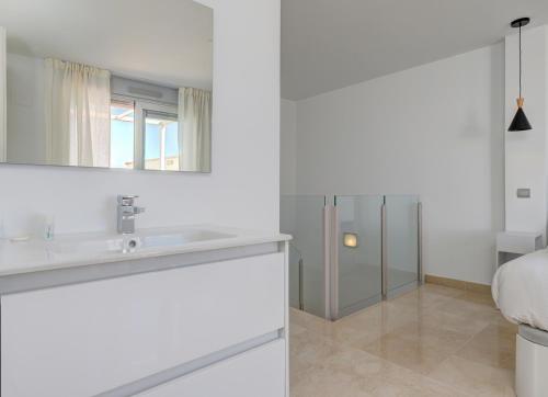 a white bathroom with a sink and a bed at Aqua Apartments Vento, Marbella in Marbella