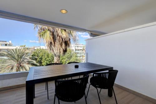 a black table and chairs in a room with a window at Aqua Apartments Vento, Marbella in Marbella